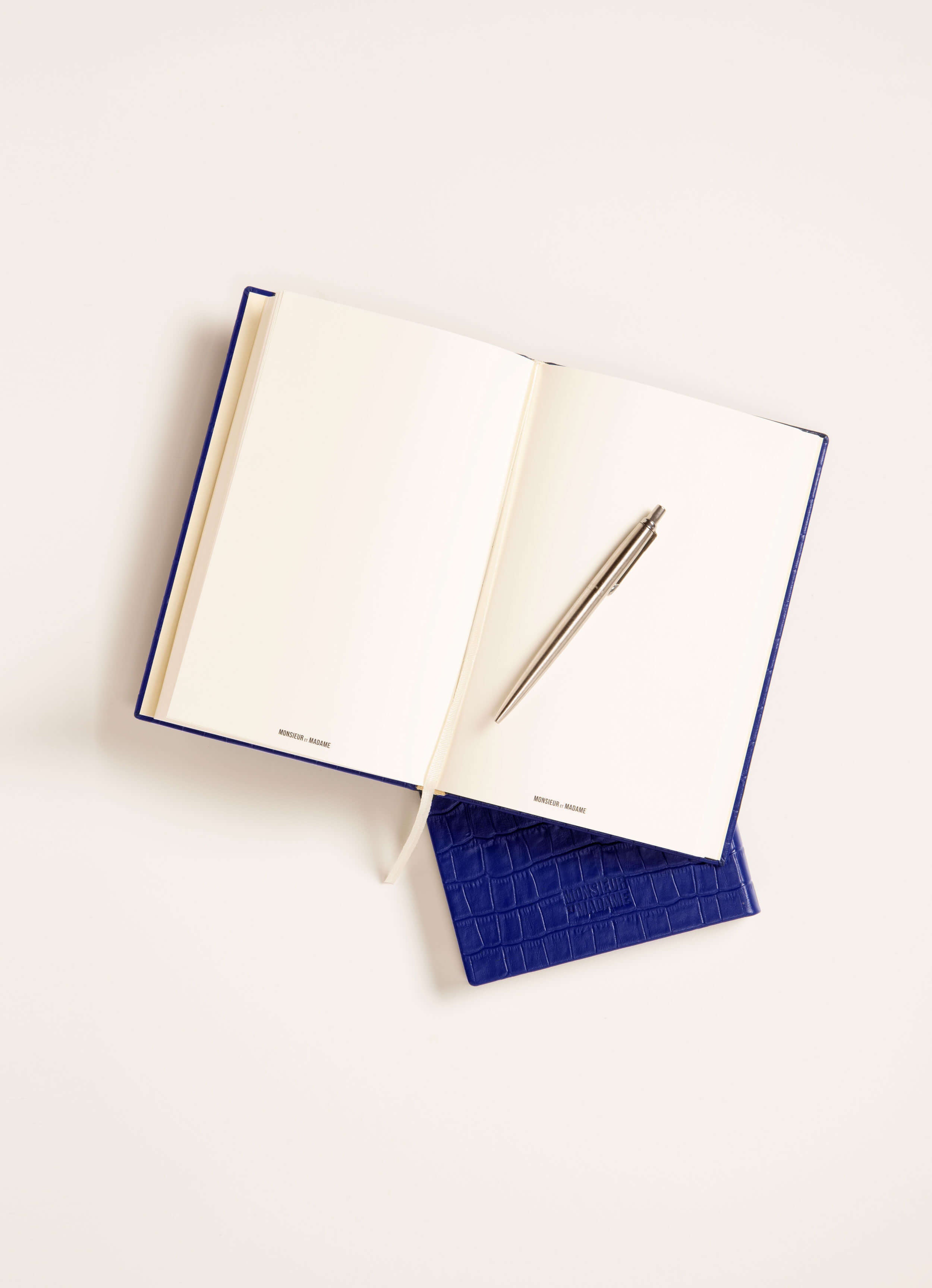 Éclipse notebook open on desk — blue croc leather with cream pages.