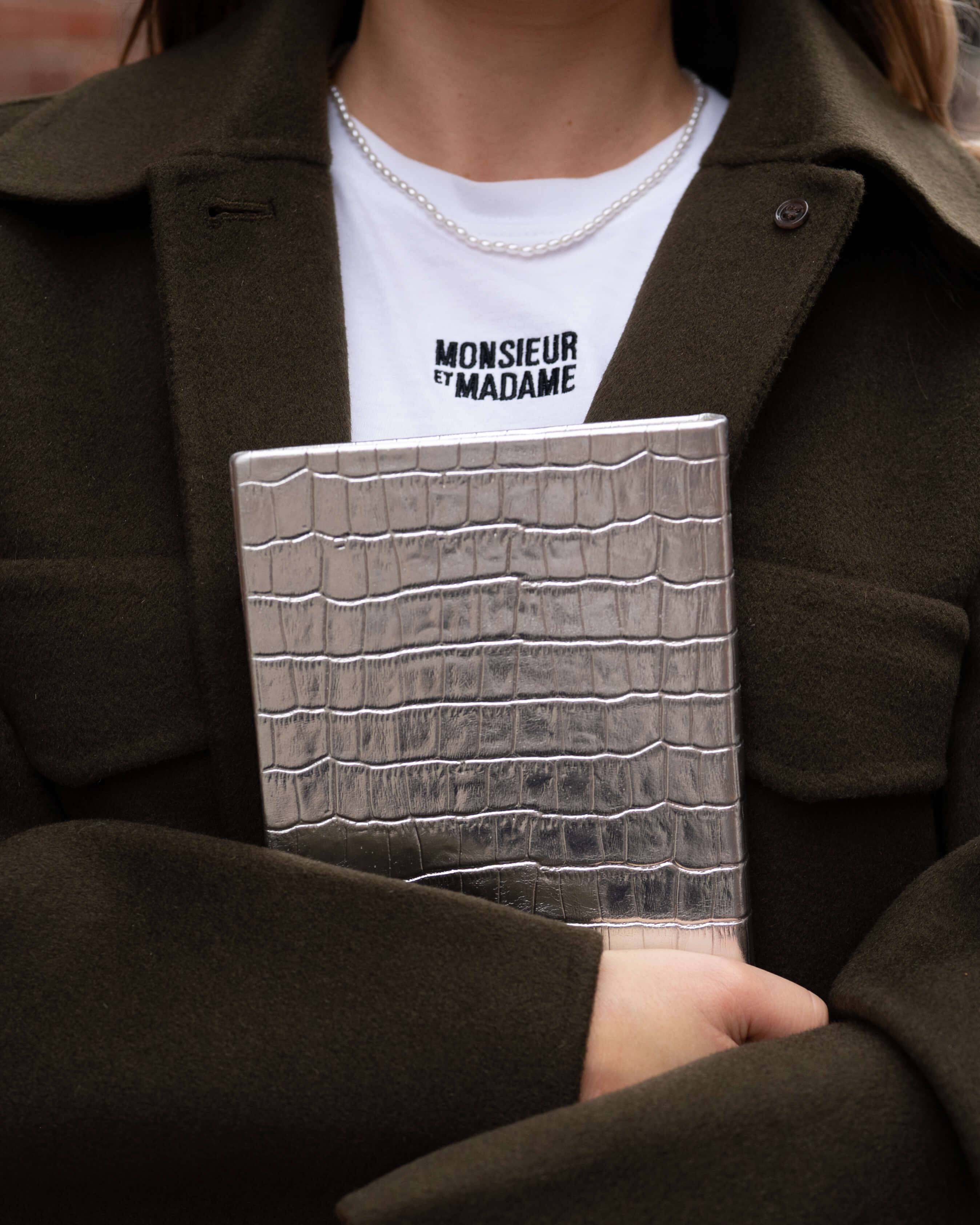 Person holding a Mirage luxury silver croc-embossed leather notebook, London-designed, handcrafted in Greece, wearing a ‘Monsieur et Madame’ shirt.